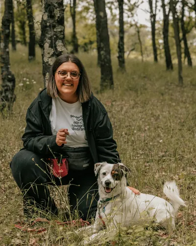 Evere accovacciata nel bosco con Poo, cane bianco